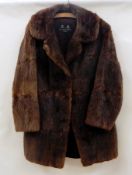 A vintage musquash fur coat carrying label 