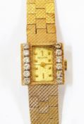 Lady's Bulova gold coloured metal and diamond set wristwatch having rectangular dial, set two rows