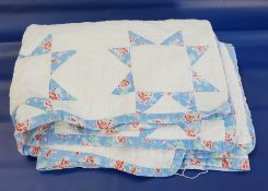 A white and blue patterned patchwork quilt backed in white  Live Bidding: If you would like a