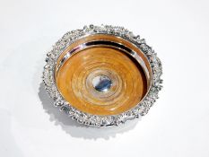 Silver plated and wood wine bottle coaster having ornate floral and scroll borders