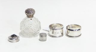 Two 20th century silver napkin rings, silver-capped glass scent bottle,