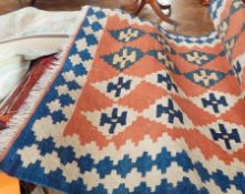 Cotton kelim with rows of cream and blue stepped guls on terracotta ground,