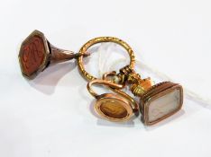 Three 19th century gold-coloured metal seals, one set with carved cornelian,