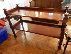 A Victorian mahogany two-tier buffet trolley with foliate carved and baluster supports, on castors,