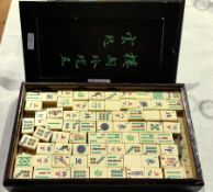 A mahjong set in a hardwood case with Oriental writing on the front
