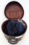 An 'Antler' hat box with shipping labels, an astrakhan and velvet Russian-style hat 