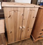 A pine cupboard with interior shelf, on bun feet, turned bun handles,
