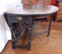 An 18th century oak oval top gateleg table, with a frieze drawer,