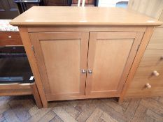 A melamine cupboard with two shelves, on block supports,