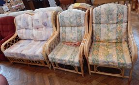 A set of garden furniture to include two cane and wicker armchairs with floral cushions and similar