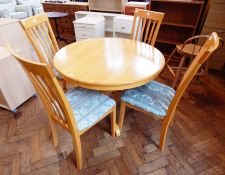 A modern beech circular top dining table on splayed supports, width 107cm, with extra leaf,