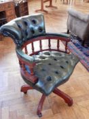 A modern button back leather office swivel armchair, with spindle back supports,