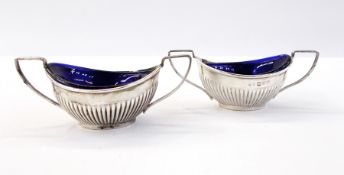 Pair of Victorian open boat-shaped salts with twin handles and half reeded form, blue glass liners,