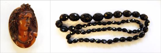 String of red amber type faceted and graduated beads and carved amber cameo,