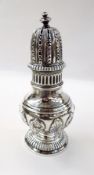 Victorian silver sugar caster with foliate repousse decoration, raised on a reeded circular foot,