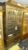 A C20th oak bookcase with leaded glazed panels on turned feet