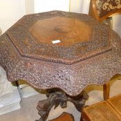A profusely carved Burmese table the octagonal top raised on carved animal triform base W 78 H 76