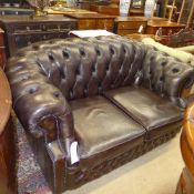 A two seater Chesterfield sofa upholstered in green button leather