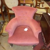 A Victorian mahogany armchair in pink fabric raised on castors