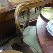 A set of four Victorian mahogany balloon back dining chairs with wrapover seats on cabriole