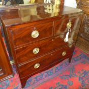 A Georgian mahogany chest having two short above two long drawers with oval brass handles on bracket