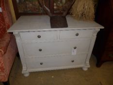A late C19th grey painted commode having two short above two long drawers on bun feet