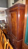 A William IV mahogany linen press the shaped corner above panel doors enclosing sliding trays with