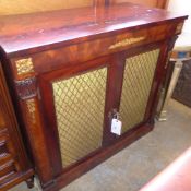 A Regency mahogany side cabinet, the rectangular top above gilt grille doors and raised on a