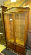 A C20th oak bookcase with leaded glazed panel doors above cupboard