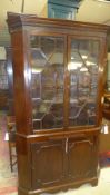 A C19th mahogany corner cabinet the blind fret carved cornice with cupboards under