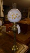 A brass and opaque shade oil lamp and a similar