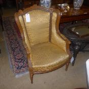 A pair of French bergere chairs with yellow foliate upholstery on carved support