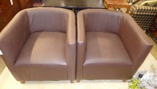 A pair of tub chairs upholstered in burgundy leatherette on square supports