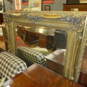 A rococo style gilded wall mirror the bevelled plate in swept frame