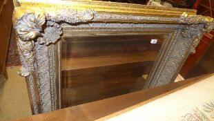 A Rococo style gilded swept wall mirror with bevelled plate