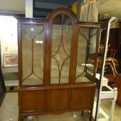An Edwardian mahogany display cabinet with astragal glazed panels above cupboards on slender