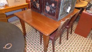 An Edwardian extending dining table with extra leaf raised on tapered support having retailer plaque