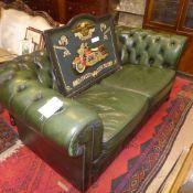 A two seater Chesterfield sofa upholstered in green button leather