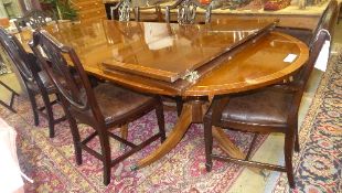 A Regency style triple pillar mahogany dining table with two extra leaves the crossbanded top raised