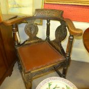 A late Victorian oak corner chair the profusely carved back above pad seat