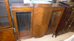 A C20th mahogany display cabinet with panel door flanked by bevelled glazed panels on cabriole
