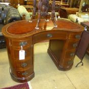 A C20th mahogany kidney shaped kneehole desk the tooled leather top above an arrangement of drawers