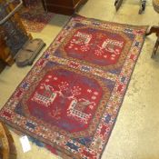 A hand knotted Persian rug the oval ground with animal motifs