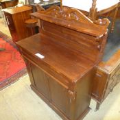 A Victorian mahogany chiffonier the carved upstand above cushion frieze drawer and cupboards on