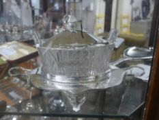 A silver plated glass butter dish on stand with lid