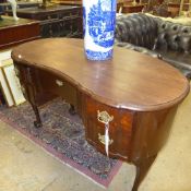 An early C20th mahogany kidney shaped desk with drawer on ball and claw supports