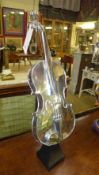 A chromium violin on stand