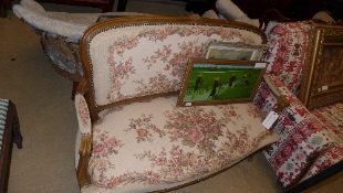 A French style walnut settee upholstered in floral needlework fabric on cabriole supports