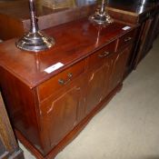 A yewood side cabinet with drawers above cupboards