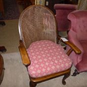 A provincial early C20th fruitwood cane back open armchair with pad cushion seat